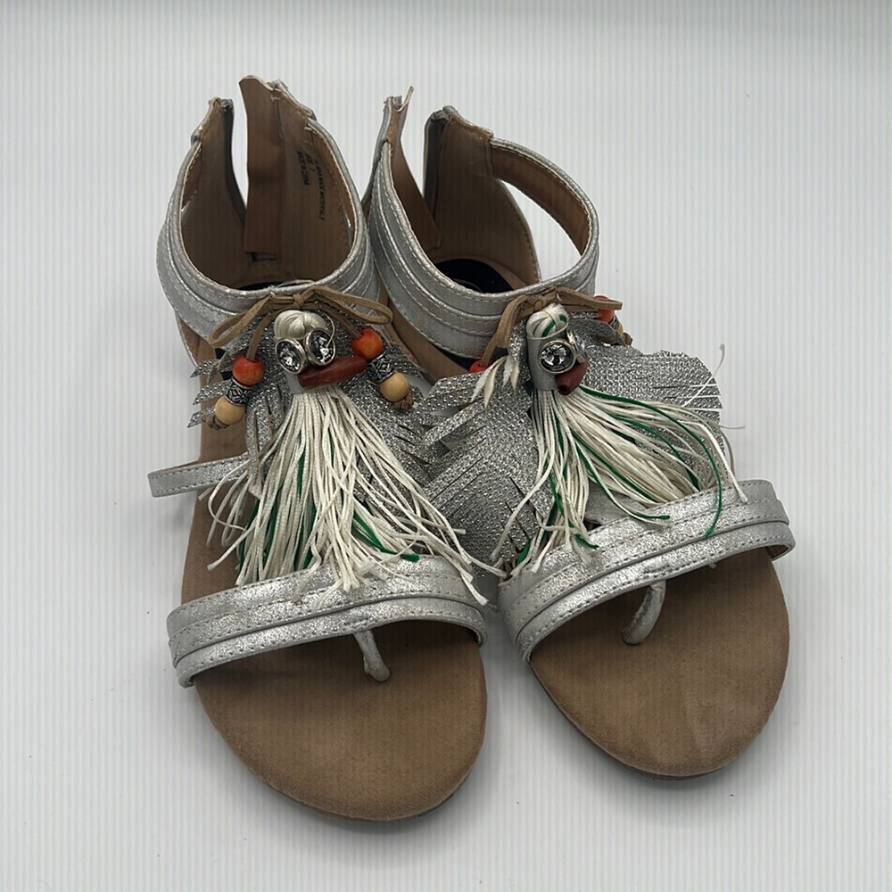 Metallic silver flat sandal with grommets and tassels size 7